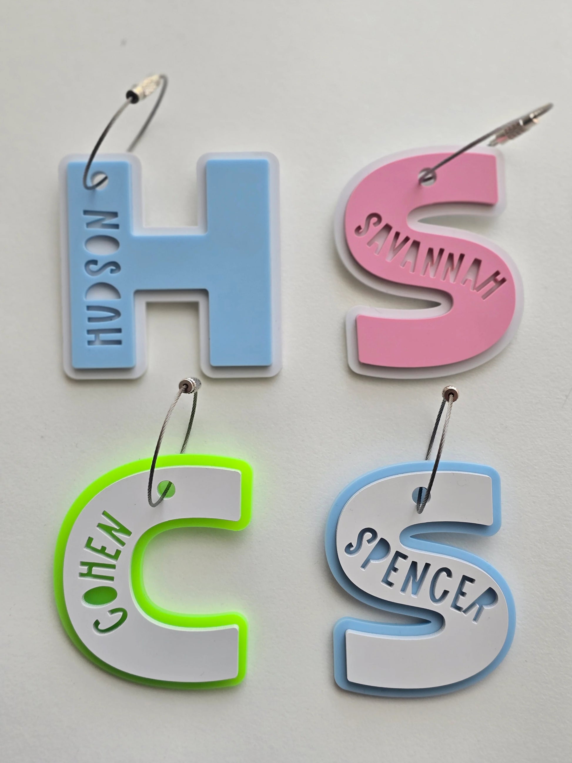 Four colorful letter-shaped name tags on a white background
