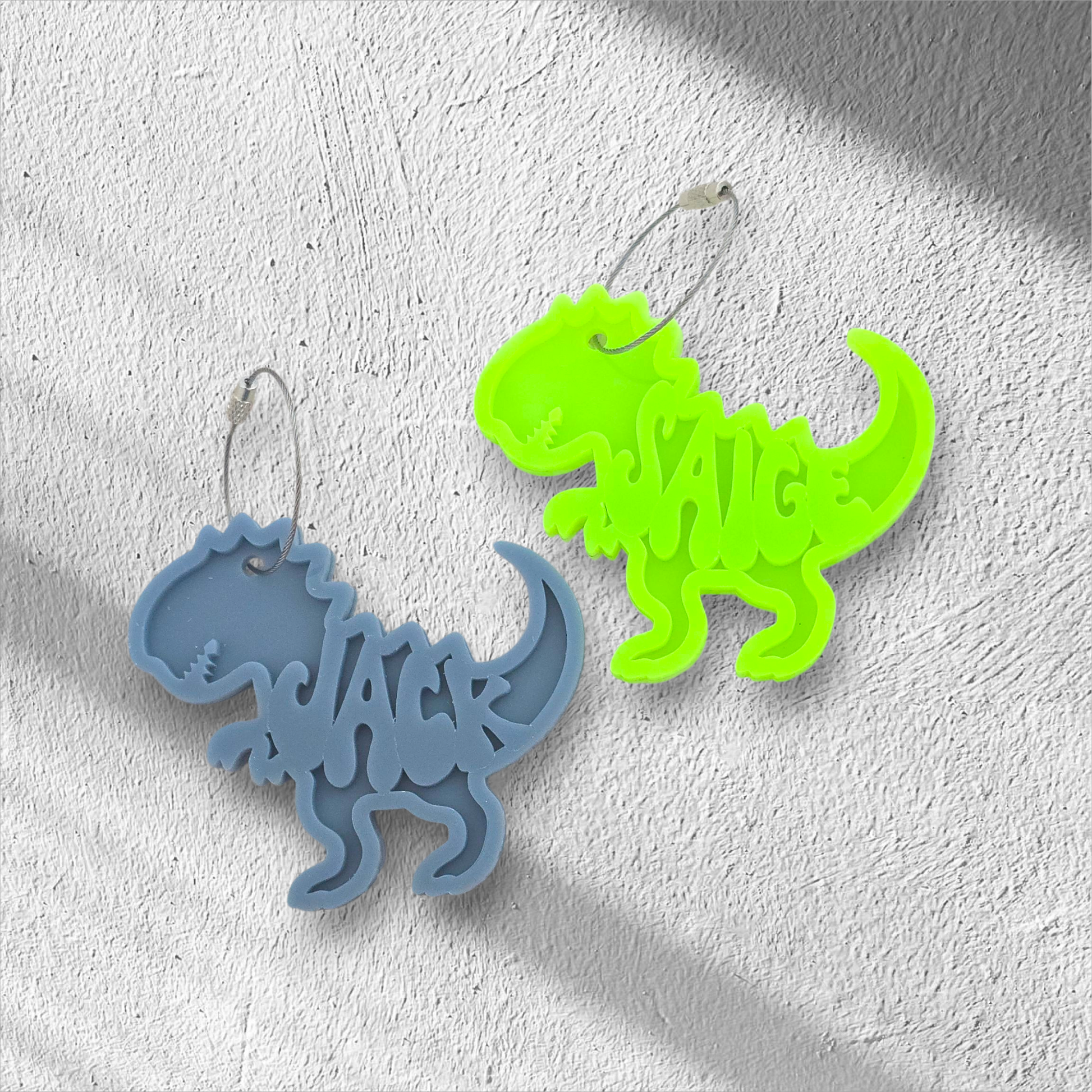 Two dinosaur-shaped keychains