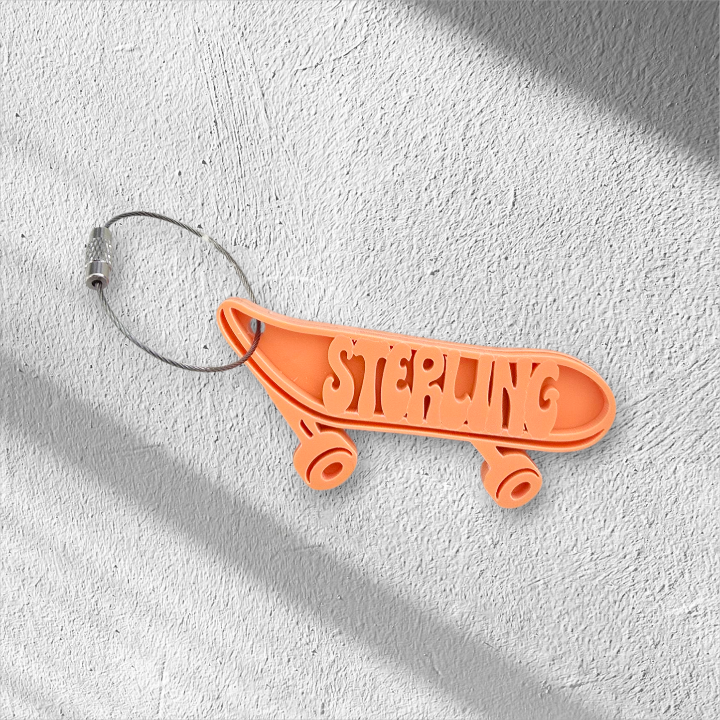 Orange skateboard-shaped keychain with custom name