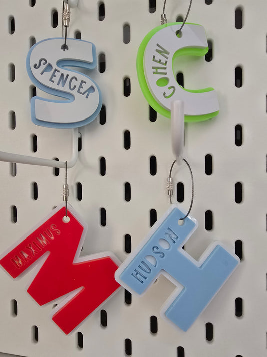 Four keychain tags with names on them